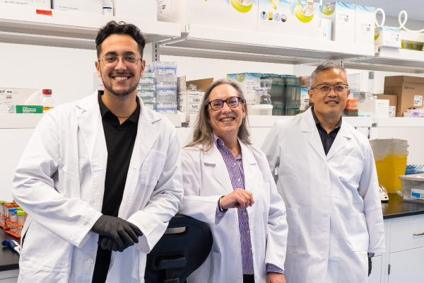 Switch scientists Joaquin Taylor, Lisa Scherer, and Raymond Kwan smiling in white lab coats
